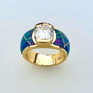 Yellow gold ring with a round Diamond Center and Cultured Opal Inlay.  Call 505-363-7150 for information.